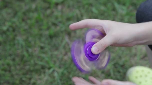Children's toy spinner. The boy plays a spinner on the street.Toy spinner in hand. — Stock Video