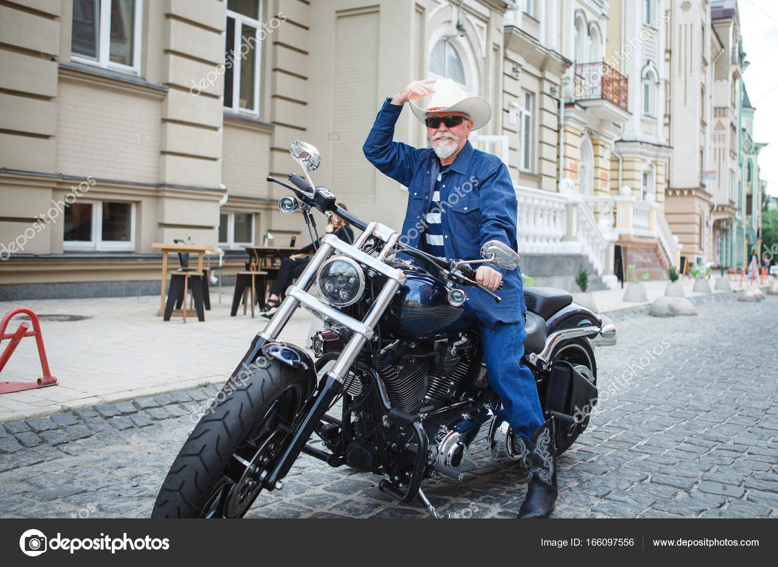 A man on a motorcycle, wearing a cowboy hat. Stock Photo by