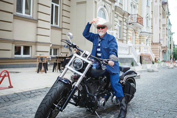一个人一辆摩托车，戴着一顶牛仔帽. 免版税图库图片
