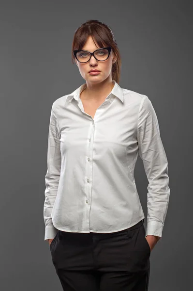 Estilo de oficina. Éxito y negocios. Gafas Girlin camisa blanca, manos en bolsillos. Retrato en el estudio . — Foto de Stock