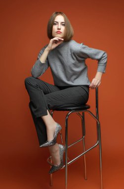 Kadın güzellik kavramı. Altın arka plan üzerinde poz klasik elbiseleri şık genç kız portresi. Mükemmel saç cilt. Vogue tarzı. Stüdyo vurdu
