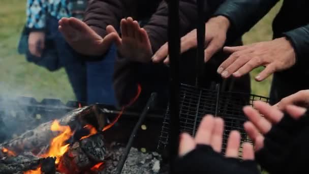 Manos frías. chicos frotándose las manos delante de la chimenea en llamas . — Vídeos de Stock