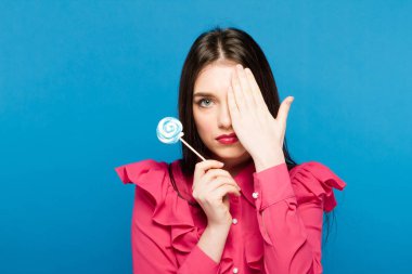 Güzel bir kadın ile bir lolipop, yüksek kaliteli güzellik mavi zemin üzerine kadar yakın