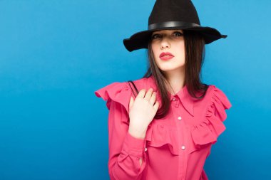 Şapkalı güzel bir kadın. Retro moda. Mavi arka plan.