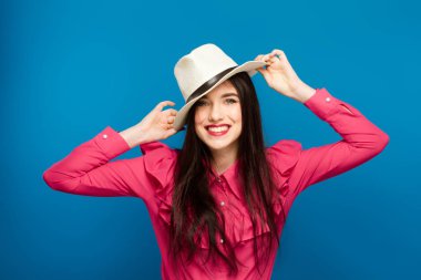 Şapkalı güzel bir kadın. Retro moda. Mavi arka plan.