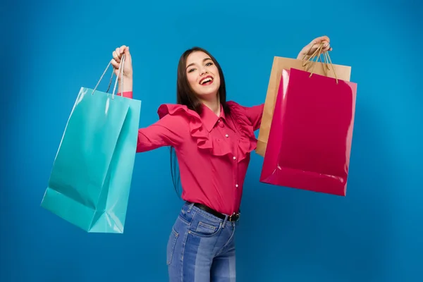 Портрет молодой счастливой улыбающейся женщины с сумками для покупок — стоковое фото