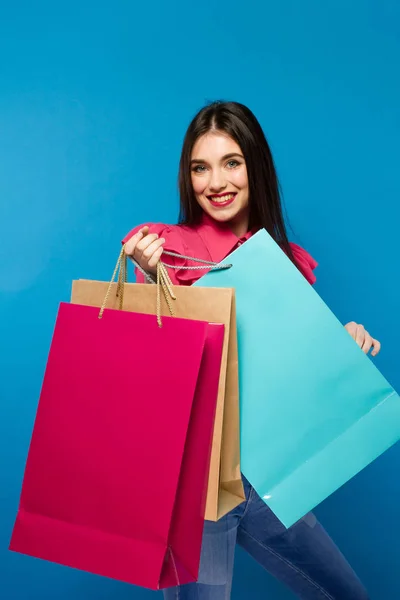 Портрет молодой счастливой улыбающейся женщины с сумками для покупок — стоковое фото