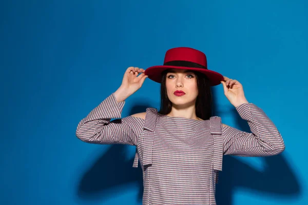 Мода Брюнетка Леди в красной шляпе и красные губы на синем фоне — стоковое фото