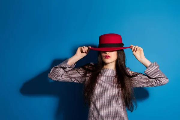 Mode Brunette Dame au chapeau rouge et lèvres rouges sur fond bleu — Photo