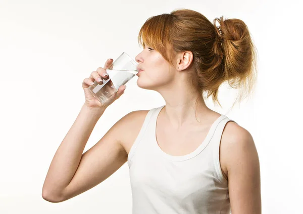 Mujer deportiva sobre fondo gris sosteniendo vaso de agua — Foto de Stock