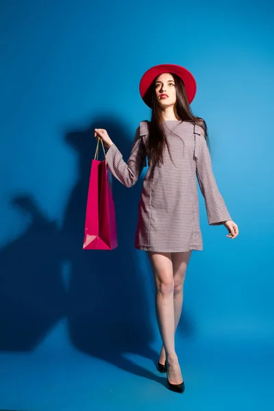 Journée shopping, fille souriante et robe en denim bleu debout à l'extérieur avec sac à provisions — Photo