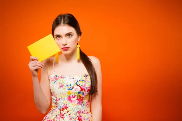 Hermosa mujer con sobre de correo. Sobre fondo naranja . —  Fotos de Stock