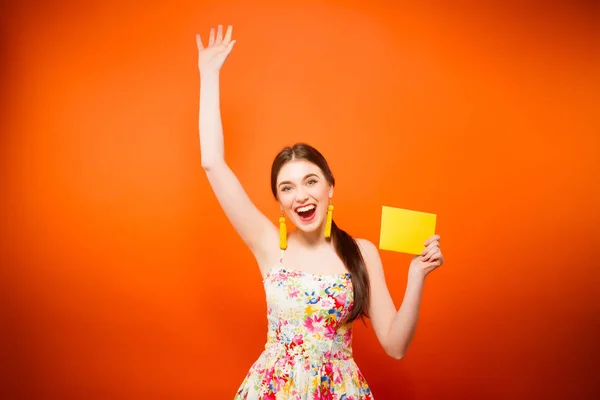 Bella donna sorridente con busta postale. Su sfondo arancione — Foto Stock