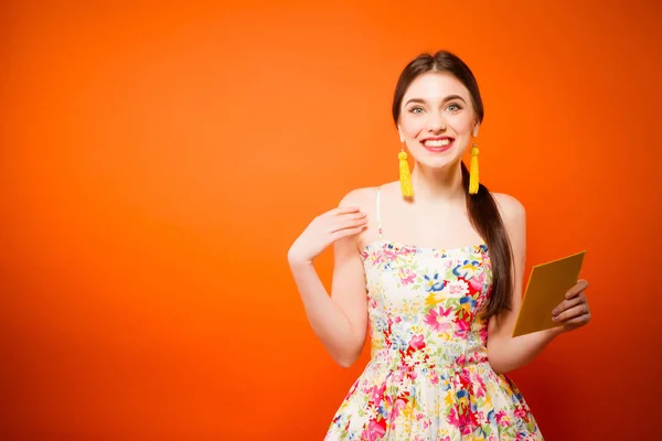 Bella donna sorridente con busta postale. Su sfondo arancione — Foto Stock