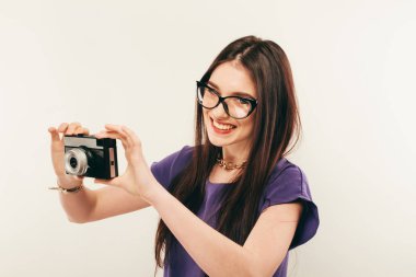 Genç gülümseyen kadın eski fotoğraf makinesi ile bir fotoğraf yapmak. Fotoğrafçı