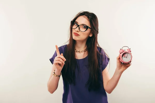 Joven mujer divertida en gafas con reloj despertador. Emoción . — Foto de Stock