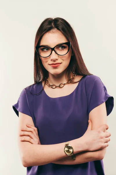 Joven hermosa mujer con expresión facial de sorpresa de pie sobre fondo gris. Llevar en vestido de moda y gafas. Mirando a la cámara — Foto de Stock