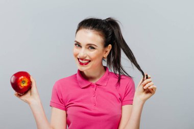 Kadın diyet gri arka plan karşı elinde bir elma