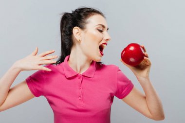 Kadın diyet gri arka plan karşı elinde bir elma