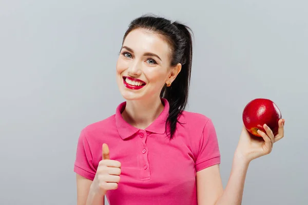 Mujer a dieta con una manzana en la mano sobre fondo gris — Foto de Stock