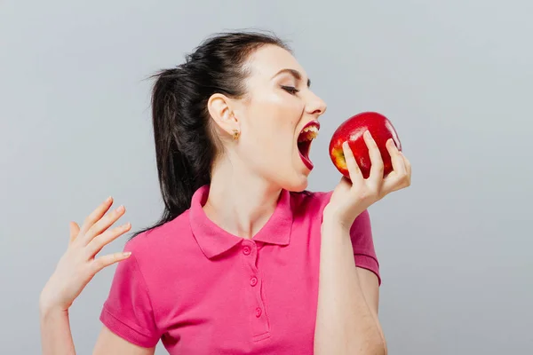 Mujer a dieta con una manzana en la mano sobre fondo gris — Foto de Stock