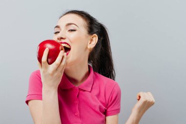 Sağlıklı mutlu, doğal organik çiğ taze gıda kavramı gri arka plan, duygu ve gülümseme, mutluluk onun elinde tutan Apple çekici kız portresi