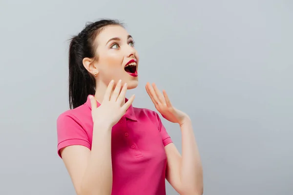 Sorprendida adolescente divertida mostrando espacio de copia vacía con su fondo gris dedo. Chica feliz —  Fotos de Stock