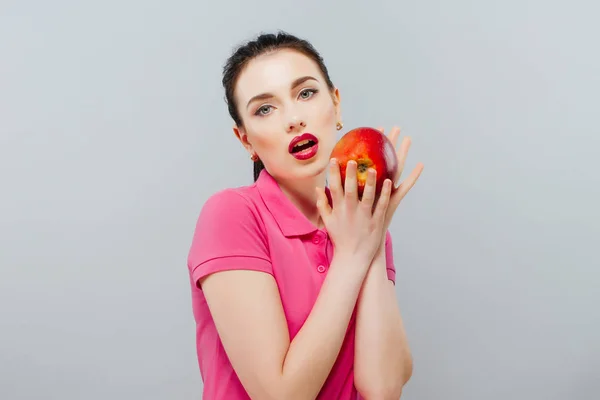 美丽的年轻女子，吃一个红苹果。孤立的白色 — 图库照片