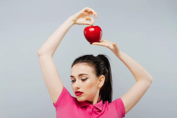 Una mujer guapa mordiendo una manzana roja . — Foto de Stock