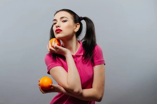 漂亮的黑发女人抱着多汁美味橙色的肖像. — 图库照片