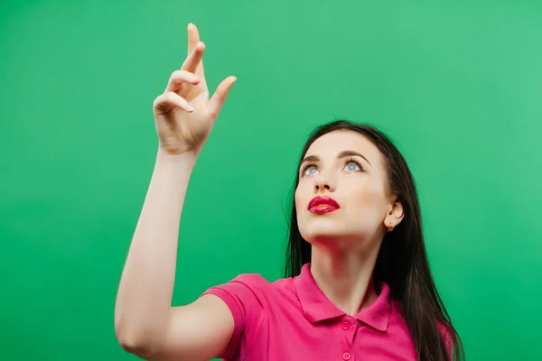 Mujer casual mirando hacia arriba - aislado sobre un fondo verde —  Fotos de Stock