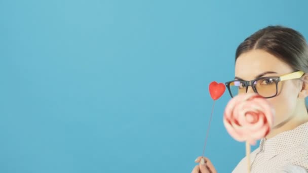 Amazingly beautiful sexy woman with Lollipop on blue background. Studio portrait of a brunette girl holding a Lollipop. makeup — Stock Video