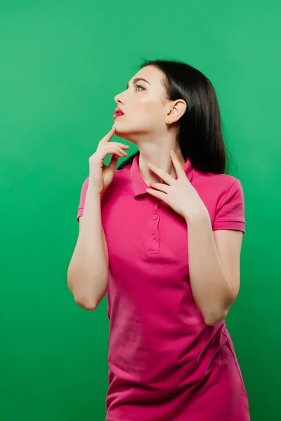 Retrato de belleza de mujer joven con maquillaje brillante en camisa rosa posando sobre fondo verde . —  Fotos de Stock