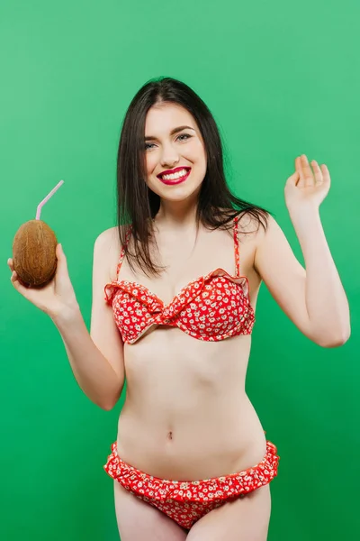 Retrato de niña inquieta posando con cóctel en estudio sobre fondo verde . — Foto de Stock