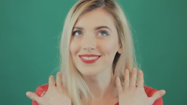Detailní portrét překvapen, mladá žena s širokým hrdlem očima na zeleném pozadí. Blond holka je Grimacing ve studiu. — Stock video