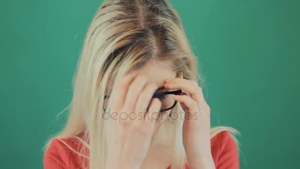 Portret van sensuele Blond meisje met lang haar op groene achtergrond in de Studio. Jonge vrouw verwijdert bril en kijkt naar de Camera. — Stockvideo