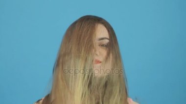 Portre güzel kadının uzun siyah saçlı ve çekici gülümseme Studio mavi zemin üzerine poz.