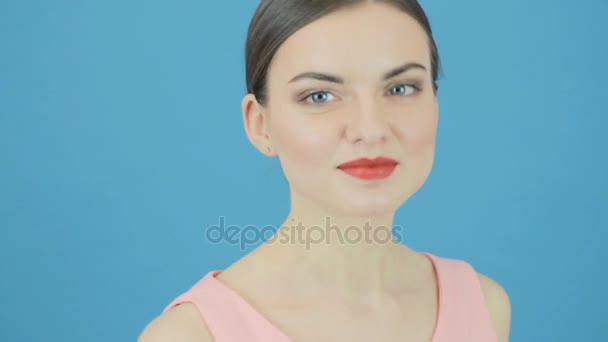 Schattige Brunette met perfecte frisse schone huid en professionele make-up op blauwe achtergrond in de Studio. Jeugd en Skin Care Concept. — Stockvideo