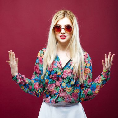 Güneş gözlüğü ve uzun saçlı pembe renkli gömlek giymiş güzel Model. Sarışın şaşırtıcı olduğunu Posing Studio.