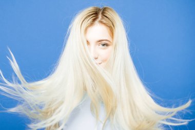 Studio mavi arka plan üzerinde Amazind uzun saçlı güzel güzel kadın baş.