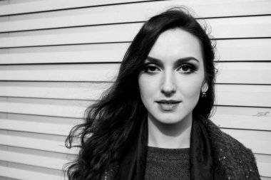 Siyah ve beyaz kentsel çekici gülümseme duvar arka plan üzerinde poz ile Bayan portresi.