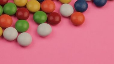 Pembe bir arka plan üzerinde renkli Çikolata kaplamalı şeker bir yığın yakın çekim