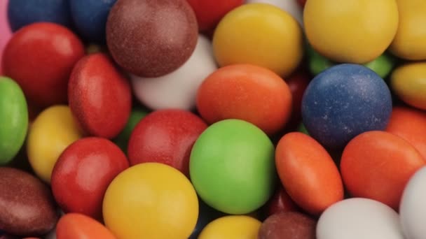 Makro der glasierten kleinen bunten Bonbons unterschiedlichster Art, die vor der Kamera rollen. Nahaufnahme — Stockvideo