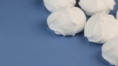 Makro Video yumuşak, kabarık, beyaz Marshmallows mavi zemin üzerine.