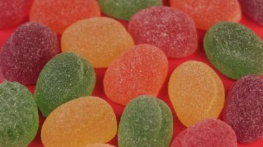 Pembe bir arka plan üzerinde renkli marmelat çeşitli. Jöle şekerler meyve kapatın.