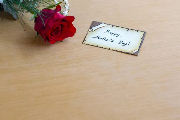 Feliz día de la madre con rosa roja en una mesa marrón —  Fotos de Stock