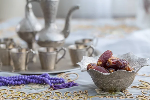 Dates with zam zam water cups background with purple rosary on w — Stock Photo, Image