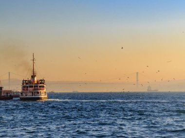 Boğaziçi Köprüsü ile gündoğumu sırasında Boğaziçi Denizi'nde feribot