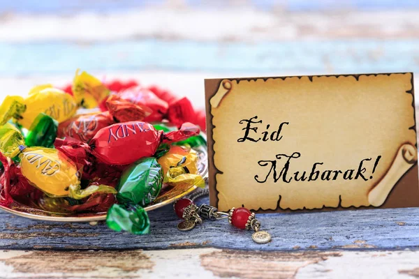 Eid mubarak en la tarjeta con caramelos de colores en la mesa vintage — Foto de Stock