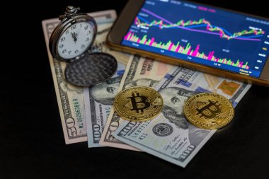 İki bitcoins, cep saati ve smartphone ile bitcoin grafiği 